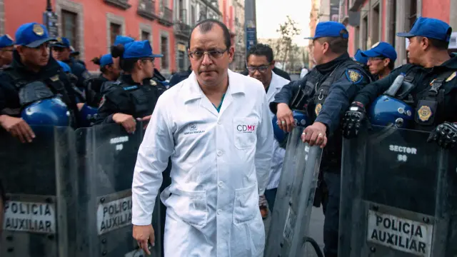 A forensic technician leaves a crime scene where four people were killed and two injured in a shooting near Mexico's National Palace, the presidential residence in the capital's historic downtown, officials said, in Mexico City, Mexico December 7, 2019. REUTERS/Nadya Murillo [[[REUTERS VOCENTO]]] MEXICO-VIOLENCE/