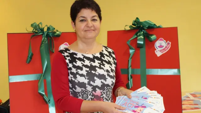 La gerente de la ACT, Ana Tarazona, posa con los vales del premio para el primer bebé del año.