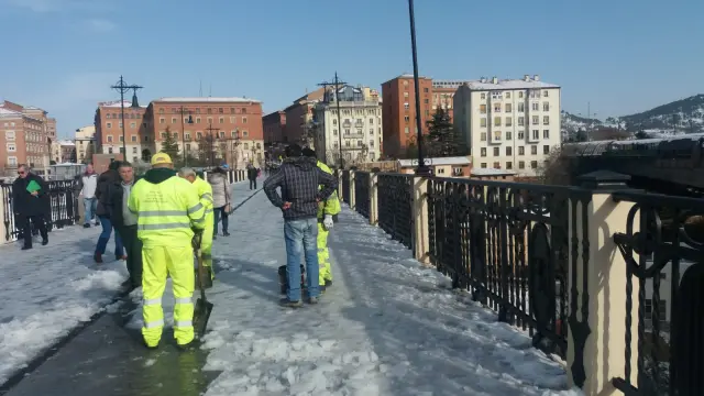 Operarios de Fomento retiran la nieve y el hielo que cubre el Viaducto Viejo de Teruel para evitar caídas.