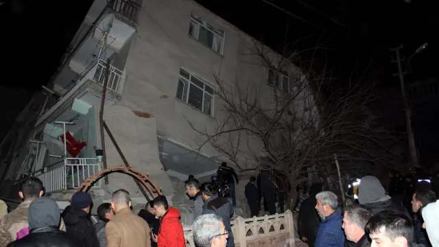 Varias personas, delante de un edificio colapsado en la ciudad de Elazig, afectada por el terremoto.