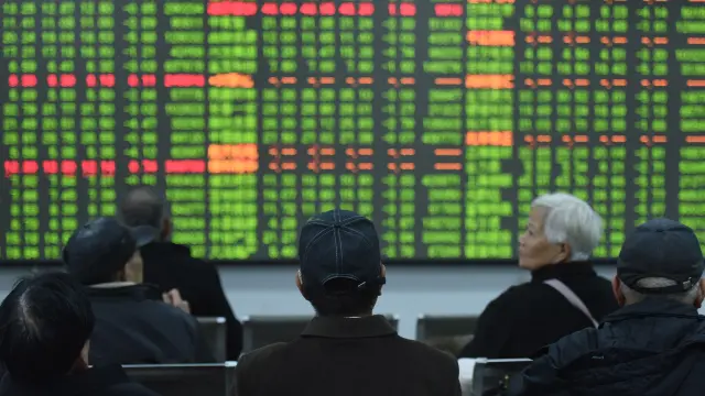 Inversores chinos miran las pantallas tras la caída de la bolsa en una sucursal de Hangzhou.