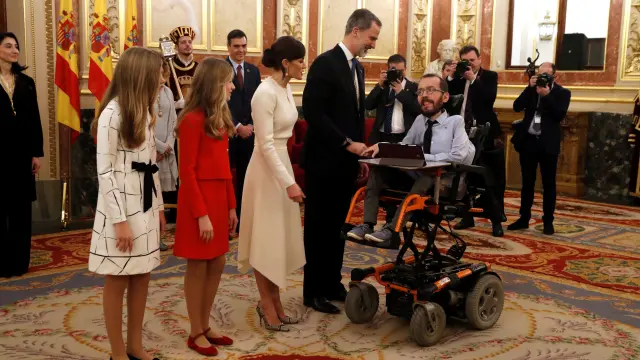 Los Reyes y sus hijas saludan al portavoz de Podemos, Pablo Echenique, en la apertura de la legislatura en el Congreso de los Diputados.