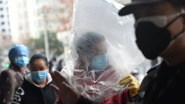 Un ciudadano chino protegido con una bolsa de plástico sobre la cabeza