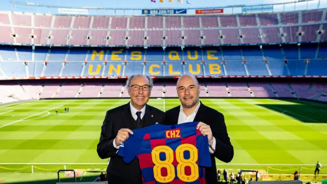Josep Pont (i), directivo del área comercial del Barcelona y Alexandre Dreyfus (d), de la empresa Chiliz, sostienen una camiseta culé para escenificar el acuerdo