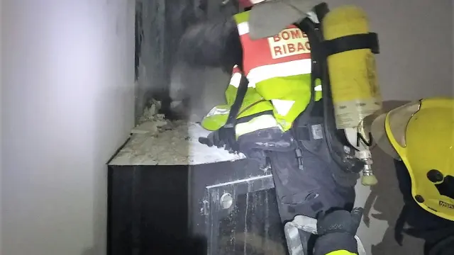 Dos bomberos comprueban la situación de la chimenea incendiada.