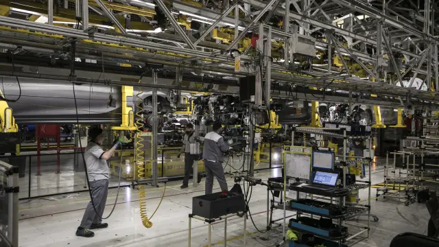Trabajadores de la planta de Opel, de PSA, en la cadena de montaje.