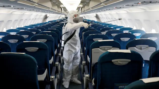 FILE PHOTO: A health worker sprays disinfectant inside a Vietnam Airlines airplane to protect against the recent coronavirus outbreak, at Noi Bai airport in Hanoi, Vietnam
