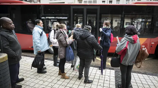 Viajeros esperando para subir al autobús de Casetas.