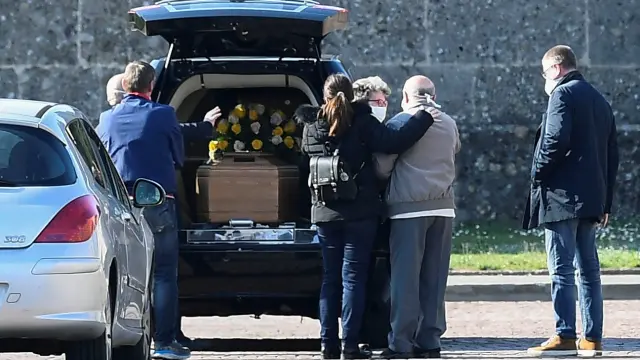 Familiares de un fallecido por coronavirus, a su llegada al cementerio de Bérgamo.