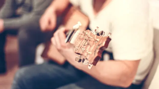 Un joven toca la guitarra.