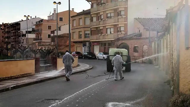 Dos operarios fumigan las calles de Alcorisa con un producto desinfectante.