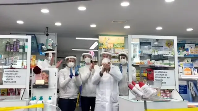 Trabajadores de una de las farmacias de Huesca con las pantallas de Luzán.