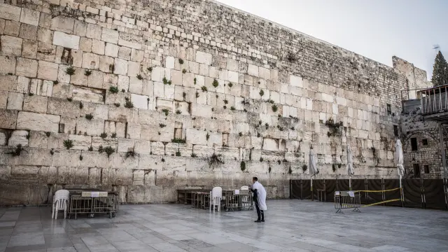 Un judío ulltraortodoxo reza ante el Muro de las Lamentaciones, vacío de fieles.