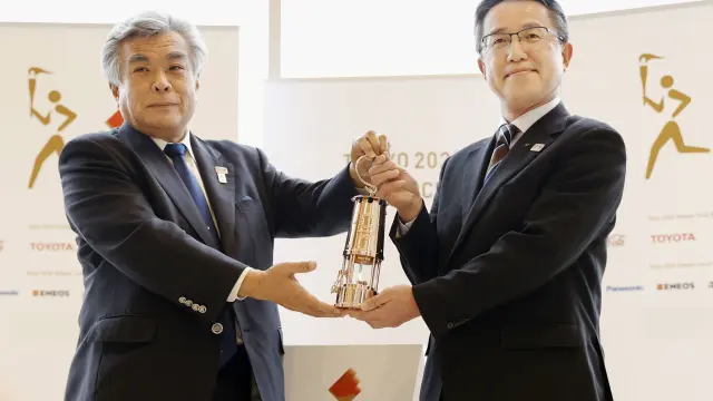 Makoto Noji, head of bureau of culture and sports for Fukushima government, holds the Olympic Flame in lantern with Tokyo 2020 COO Yukihiko Nunomura during an official "handover ceremony" in Naraha Twon, Fukushima, Japan