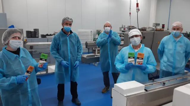 Trabajadores de Nakoa muestran las nuevas tabletas elaboradas en la planta de Utebo.