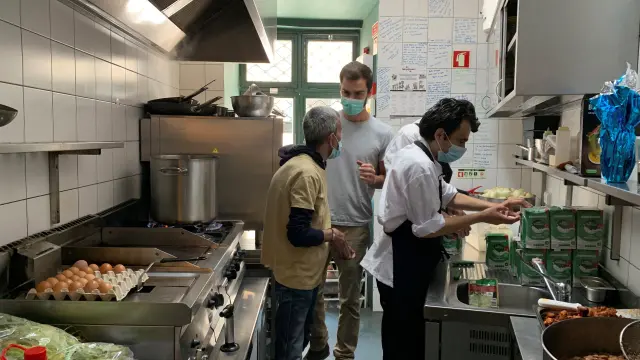 Trabajadores de un restaurante preparan menús para personas sin hogar en Lisboa este domingo.