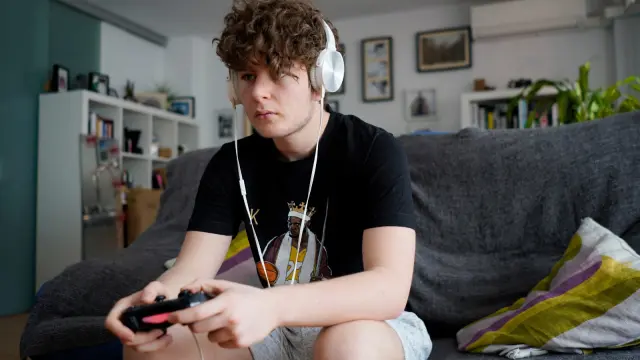 Adrián Castillo Albuixech, en su casa, jugando a la PlayStation, con la que también se conecta con sus amigos