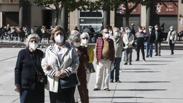 Gente con mascarilla haciendo fila para entrar en la basílica del Pilar de Zaragoza