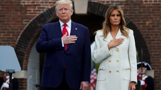 U.S. first lady Melania Trump watches as President Donald Trump salutes while participating in a wreath laying ceremony at the Tomb of the Unknown Soldier at Arlington National Cemetery near Washington in commemoration of the Memorial Day holiday in Arlington, Virginia, U.S., May 25, 2020. REUTERS/Erin Scott [[[REUTERS VOCENTO]]] USA-TRUMP/