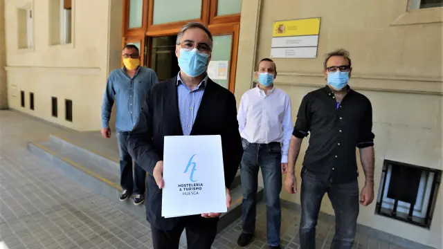 Carmelo Bosque, acompañado de otros representantes de la Asociación Provincial de Hostelería, delante de la subdelegación del Gobierno en Huesca, donde entregaron el manifiesto.