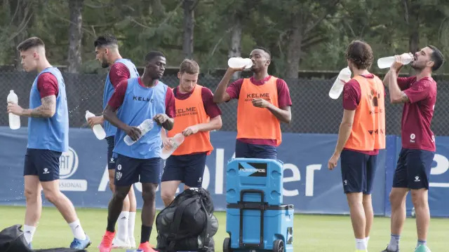 Los jugadores de la SD Huesca se hidratan durante el entrenamiento del miércoles.