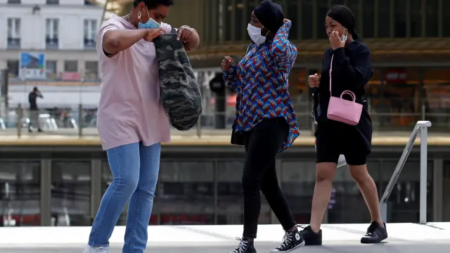 Tres personas con mascarilla, en una zona comercial del centro de París, este jueves.