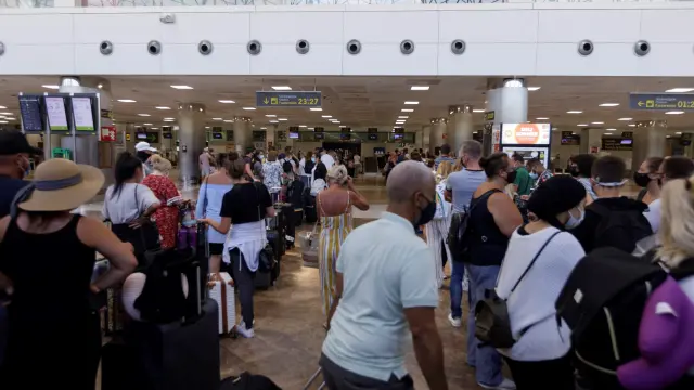 Viajeros con destino al Reino Unido hacen cola este domingo para facturar en el aeropuerto de Tenerife.