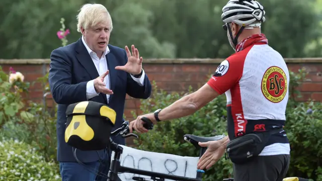 Britain's Prime Minister Boris Johnson talks to cyclist Robert Cleave at the Canal Side Heritage Centre in Beeston