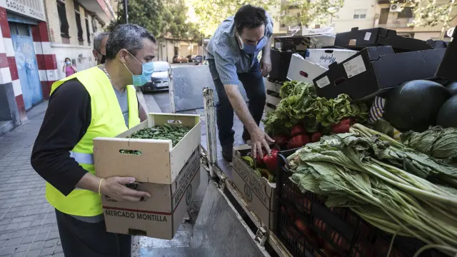 Voluntarios de la Asociación de Vecinos Cívitas del barrio de Las Fuentes descargan el camión con los alimentos este pasado viernes.