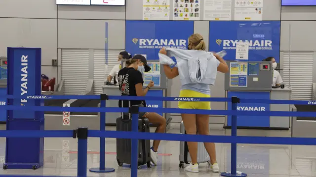 Dos jóvenes esperan a hacer el check in con la compañía Ryanair, este martes en el aeropuerto de Palma de Mallorca.