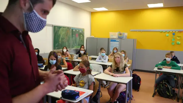Schoolgirls and schoolboys of the fifth year voluntarily wear protective face masks inside their classroom as schools re-open after summer holidays and the lockdown due to the outbreak of the coronavirus disease (COVID-19) at the Karl-Rehbein high school in Hanau, Germany, August 17, 2020. REUTERS/Kai Pfaffenbach [[[REUTERS VOCENTO]]] HEALTH-CORONAVIRUS/GERMANY-EDUCATION