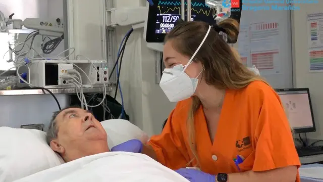 Una sanitaria del Hospital Gregorio Marañón junto al paciente con la covid que más tiempo ha estado ingresado en la UCI, con 158 días.