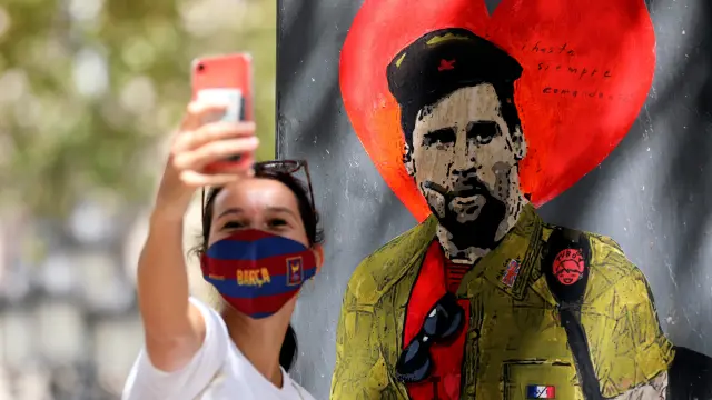 Una mujer se toma un serfi con un mural del astro argentino en Barcelona