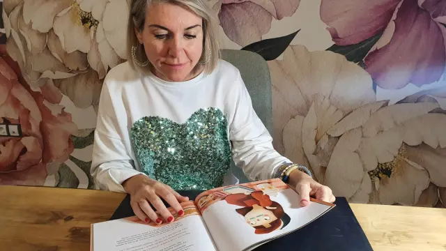 La psicóloga Gabriela Lardiés, con el cuento premiado ilustrado por Mamen Marcén, en su consulta de la capital aragonesa.