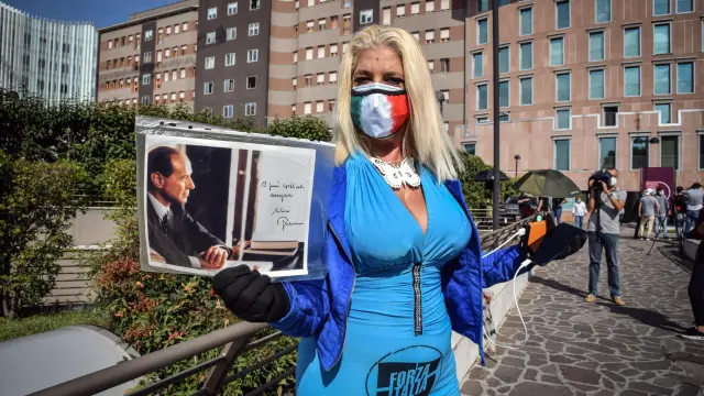 Una seguidora de Berlusconi, delante del hospital San Raffaele de Milán donde está ingresado