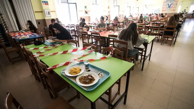 Las plazas de las mesas de comedor están marcadas con cintas de balizar en el comedor del colegio mayor Pedro Cerbuna de Zaragoza