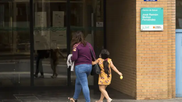 Una niña, acompañada por una adulta, accede ayer a un centro de salud de Zaragoza.