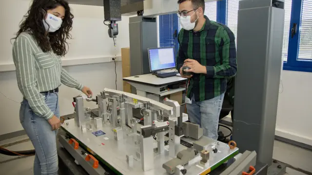 Los ingenieros Silvia Vicén y Pablo Rodríguez, con una de las máquinas para testear piezas