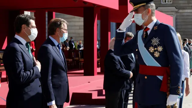 El Rey saluda al presidente de Andalucía, Juanma Moreno, durante el acto organizado con motivo del Día de la Fiesta Nacional, este lunes en Madrid.