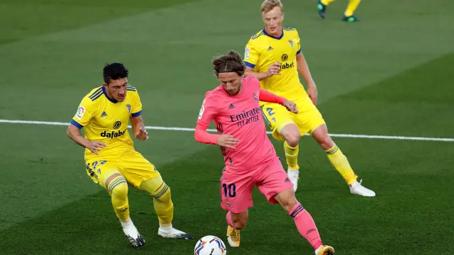 El centrocampista del Real Madrid Luka Modric (c) juega un balón entre Luis Espino (i) y Jens Jonsson, ambos del Cádiz