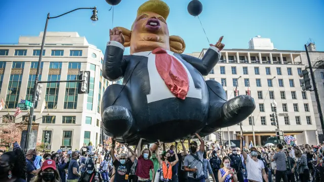 Un globo de una caricatura de Trump es aupado por seguidores de Biden en una manifestación en Washington tras las elecciones