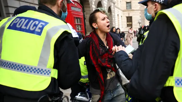 Una persona contraria al confinamiento se encara con los policías este sábado en Londres.
