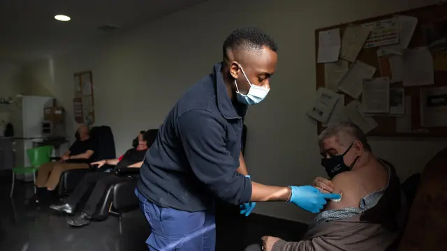 Varios miembros de la Hermandad de la Sangre de Cristo reciben la vacuna contra la pandemia en el centro Inocencio Jiménez, en Delicias.