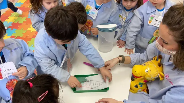 Escolares de infantil con sus experimentos en claser.