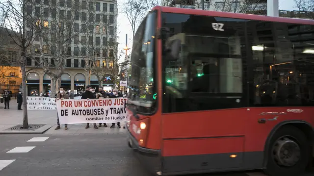 Un bus urbano pasa junto a una concentración de protesta del comité de empresa.