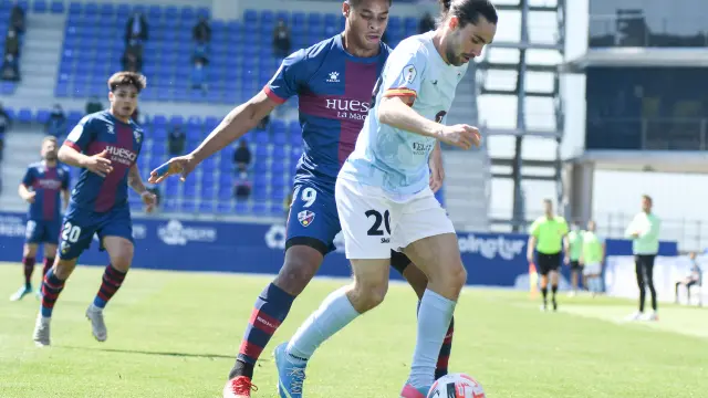 Barba, del Brea, protege el balón ante la presión de Carlos Kevin, del Huesca B.