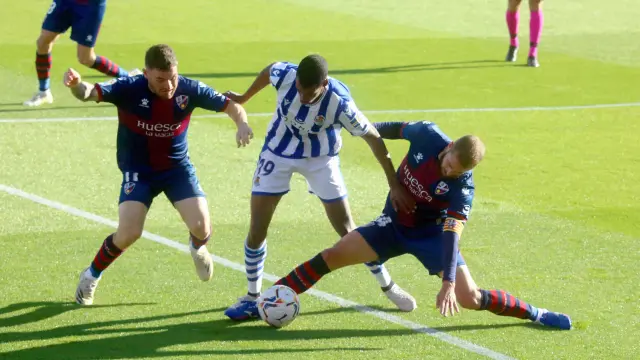 Pulido trata de cortar con Galán el avance de Isak durante el choque entre la SD Huesca y la Real Sociedad.