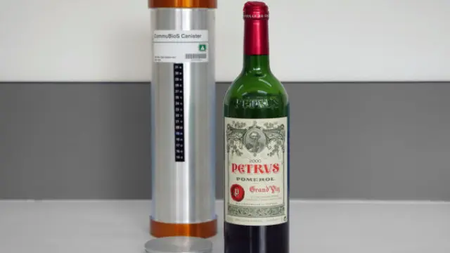 La botella de Petrus, junto a la cápsula en la que envejeció en la Estación Espacial.