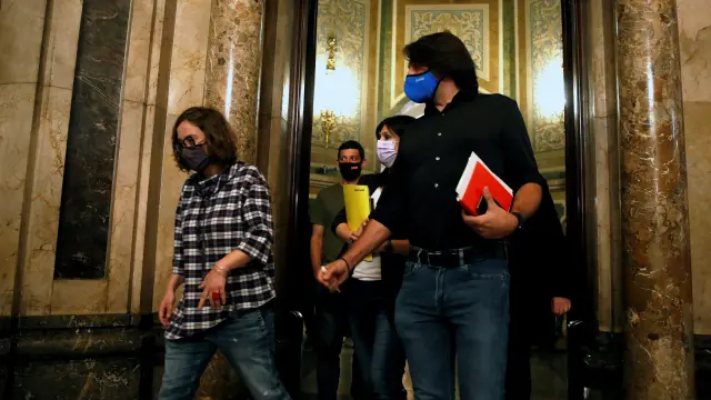 Los negociadores de la CUP, ERC y JxCat, en los pasillos del Parlament de Cataluña.
