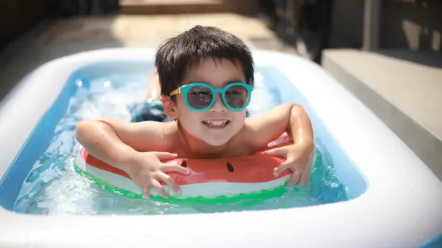Niño disfrutando de su piscina hinchable en la terraza